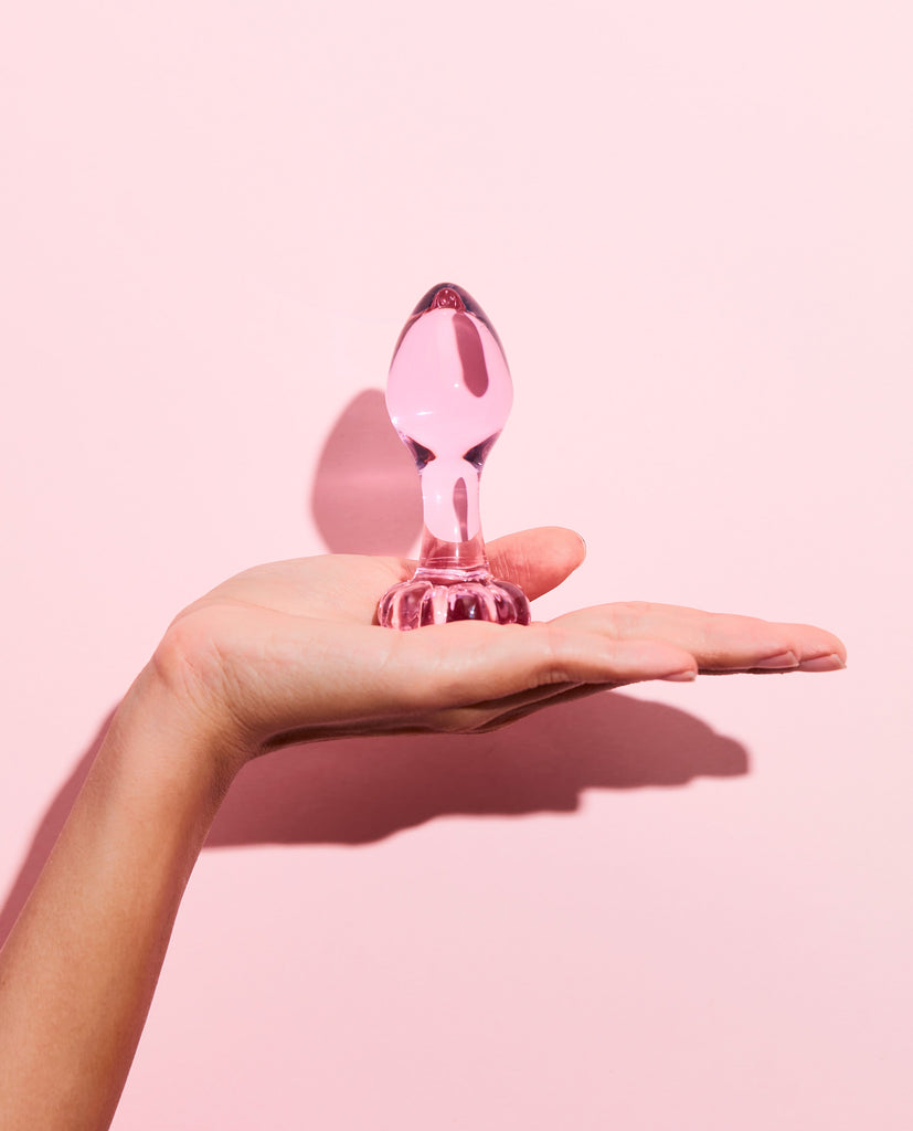 Hand holding Pink blossom glass anal plug