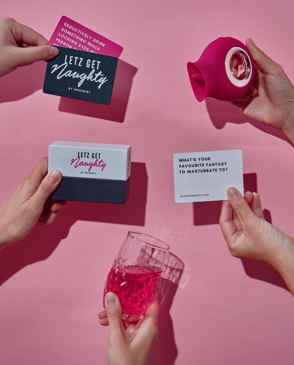 Box of Letz Get Naughty Cards, pink dare card, white truth card, pink silicone venus licking vibrator, pink drink