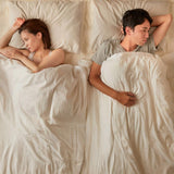 unhappy couple facing away from each other in bed