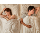 unhappy couple facing away from each other in bed