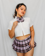 Woman wearing a white crop top and plaid skirt with a bow tie japanese schoolgirl costume