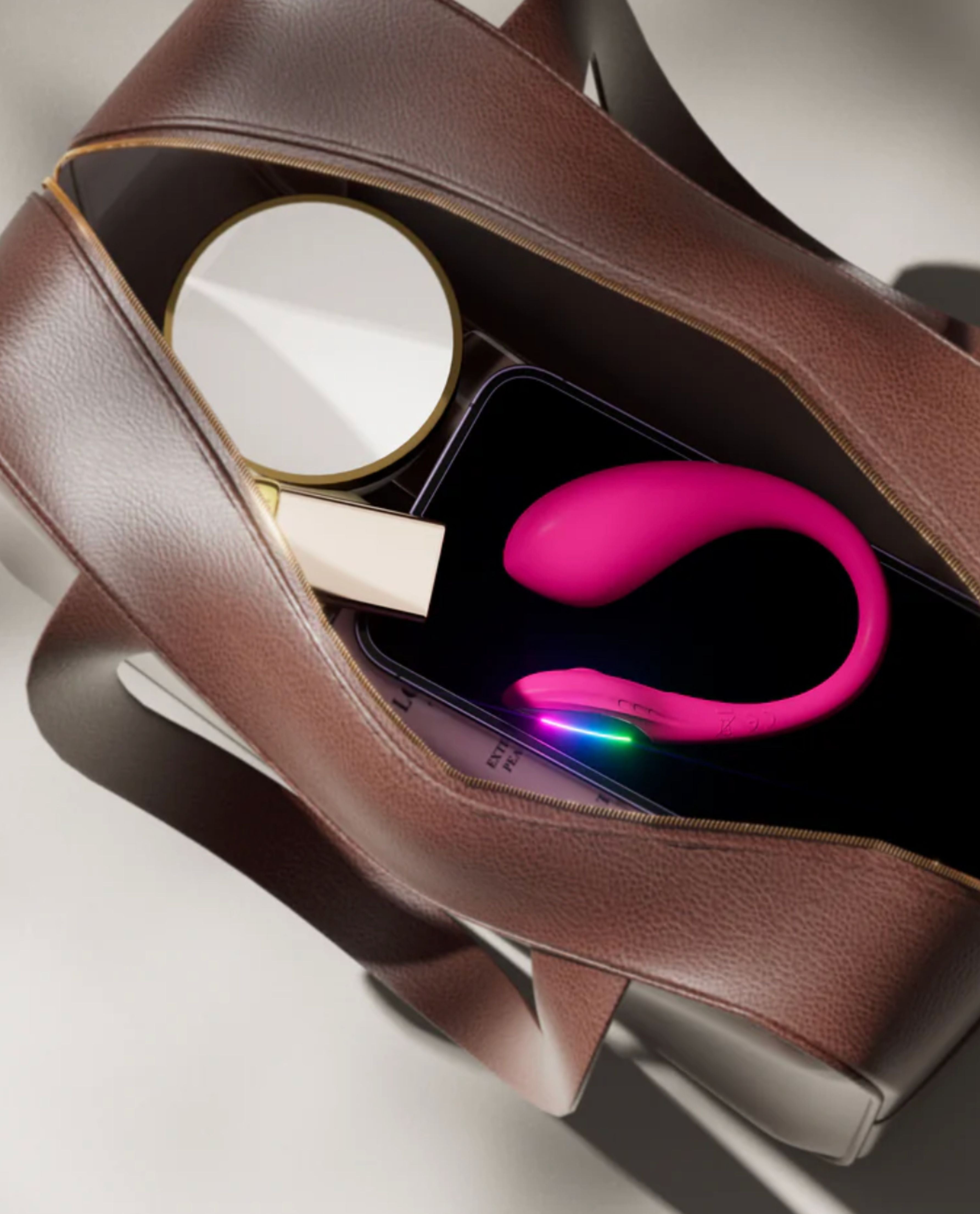 Lush Mini vibrator inside a brown handbag on a light gray background
