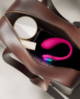 Lush Mini vibrator inside a brown handbag on a light gray background