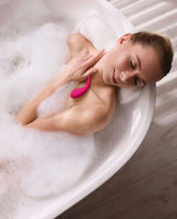 Woman in a bubble bath with a Lovense Lush Mini.