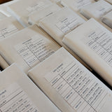 Stack of white books with printed text on a light background.