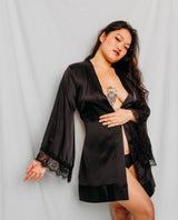 Woman wearing a black satin robe with lace trim