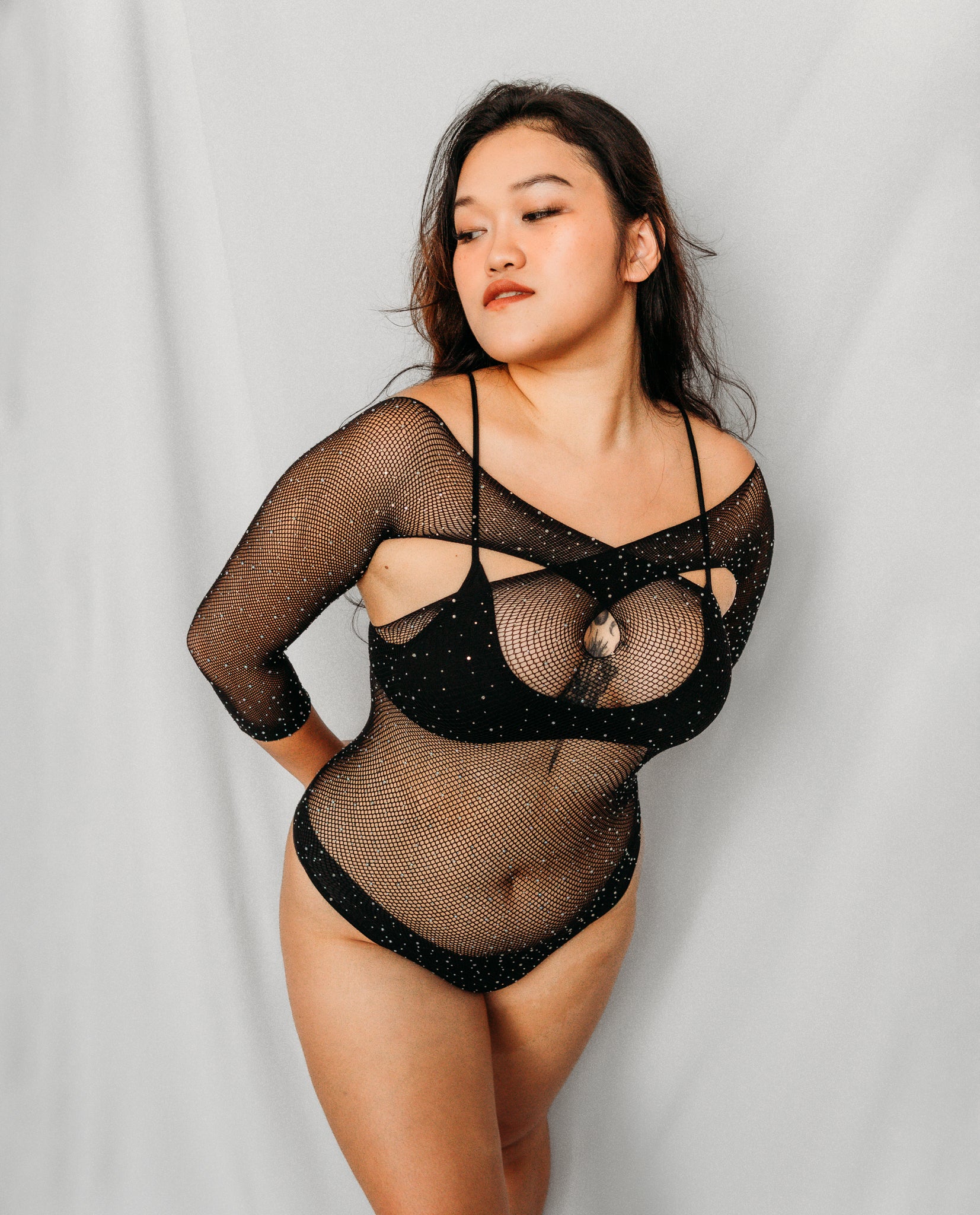 Woman wearing a black fishnet bodysuit
