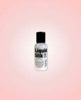 Bottle of Liquid Silk 50ml on a pink gradient background