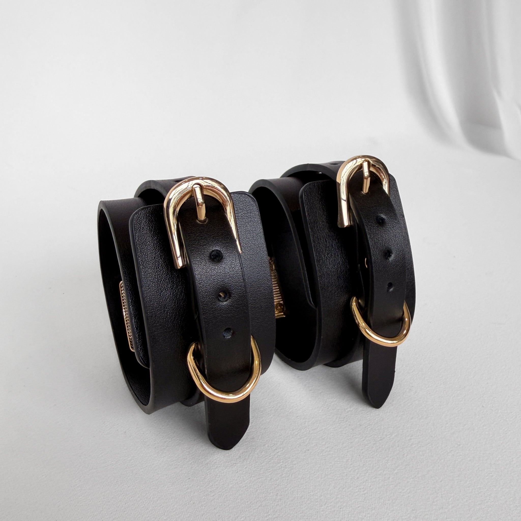Three black leather bracelets with gold buckles