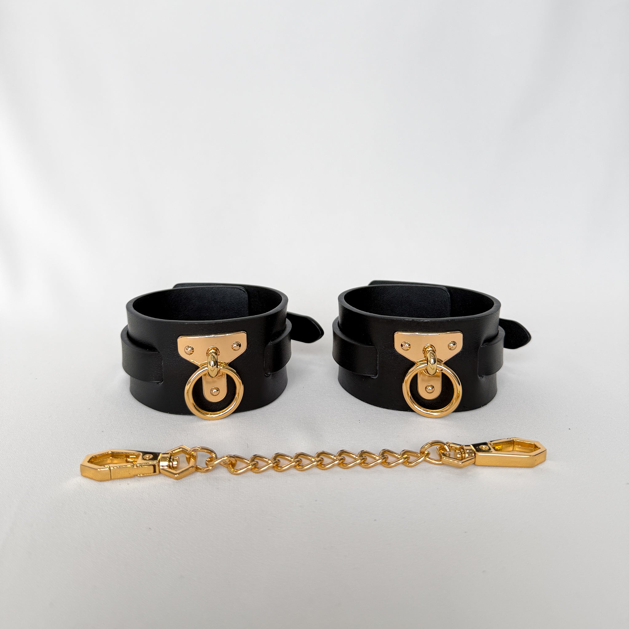 Black leather cuffs with gold hardware