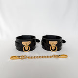 Black leather cuffs with gold hardware