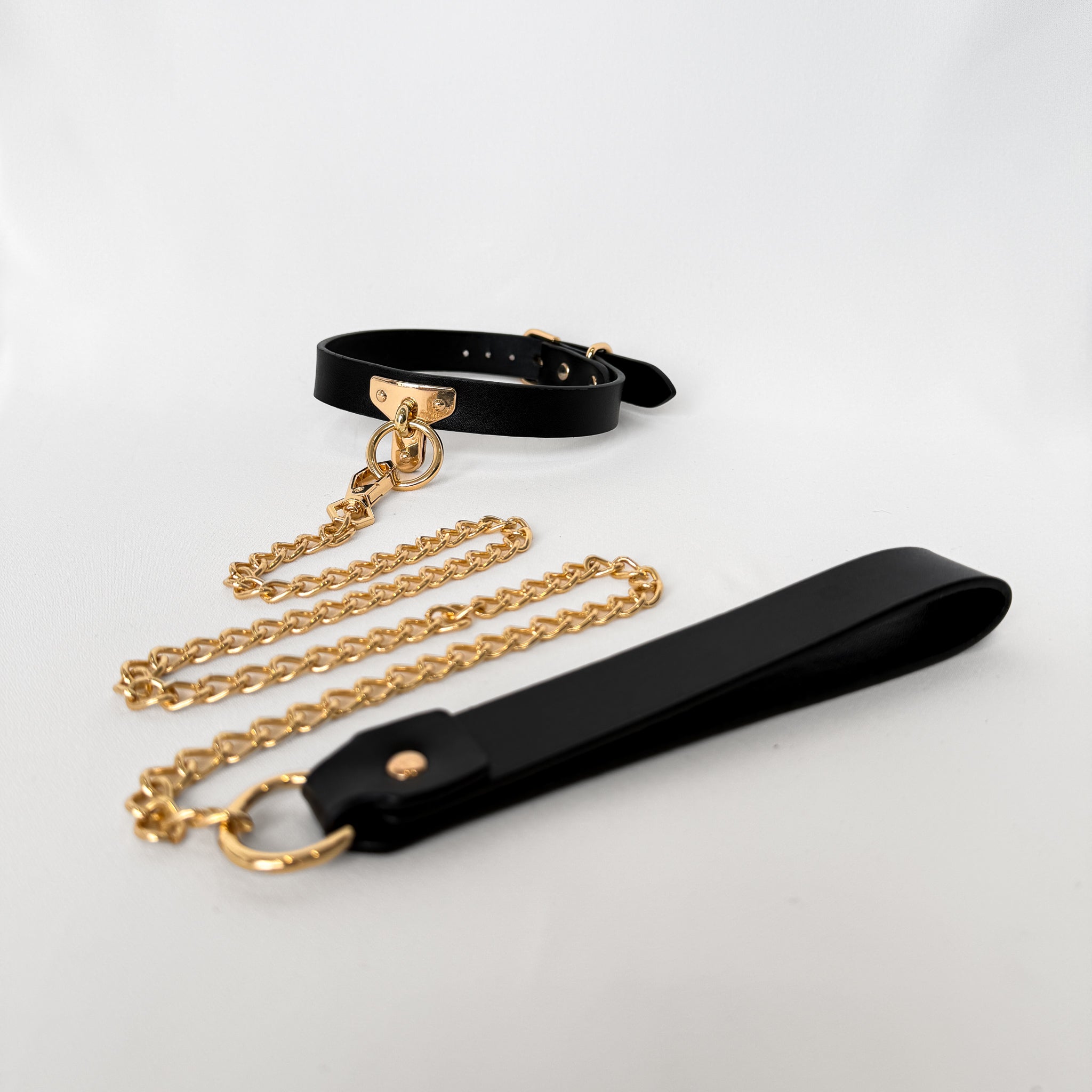 Black leather collar with gold chain and black leather strap