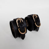 Two black leather cuffs with gold buckles 
