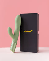 green mystique thruster rabbit vibrator next to a black box with 'Hedonist' branding on a pink background