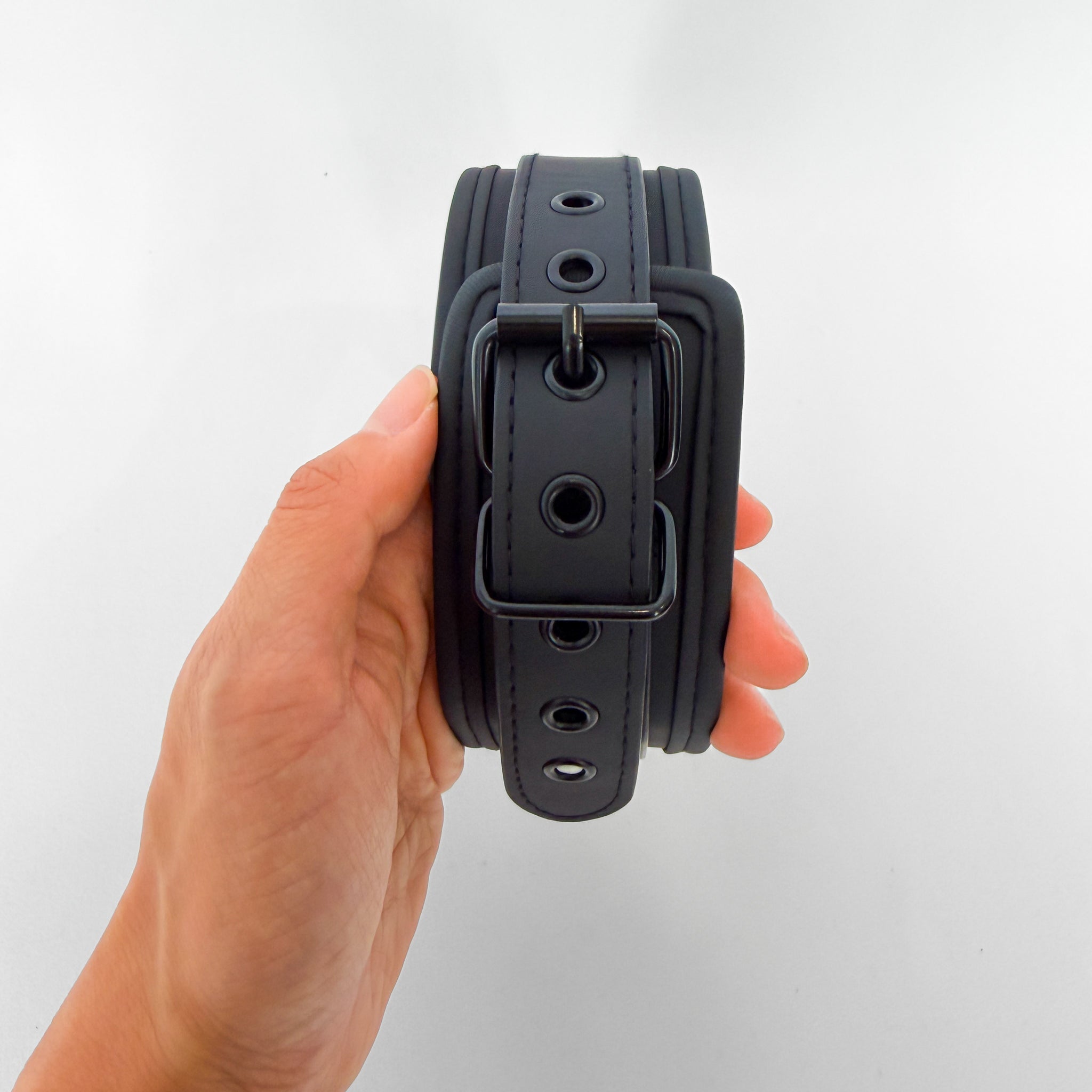 Black leather collar held by a hand