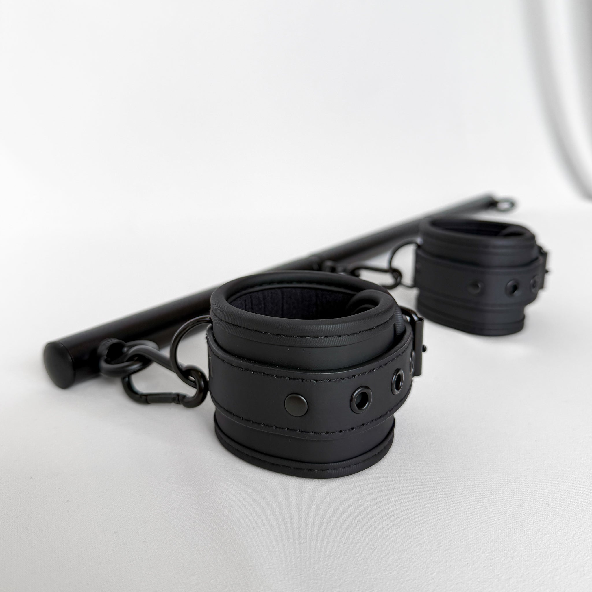 Black leather handcuffs with spreader bar rod