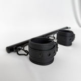 Black leather handcuffs with spreader bar rod