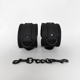 Pair of black leather cuffs with a chain