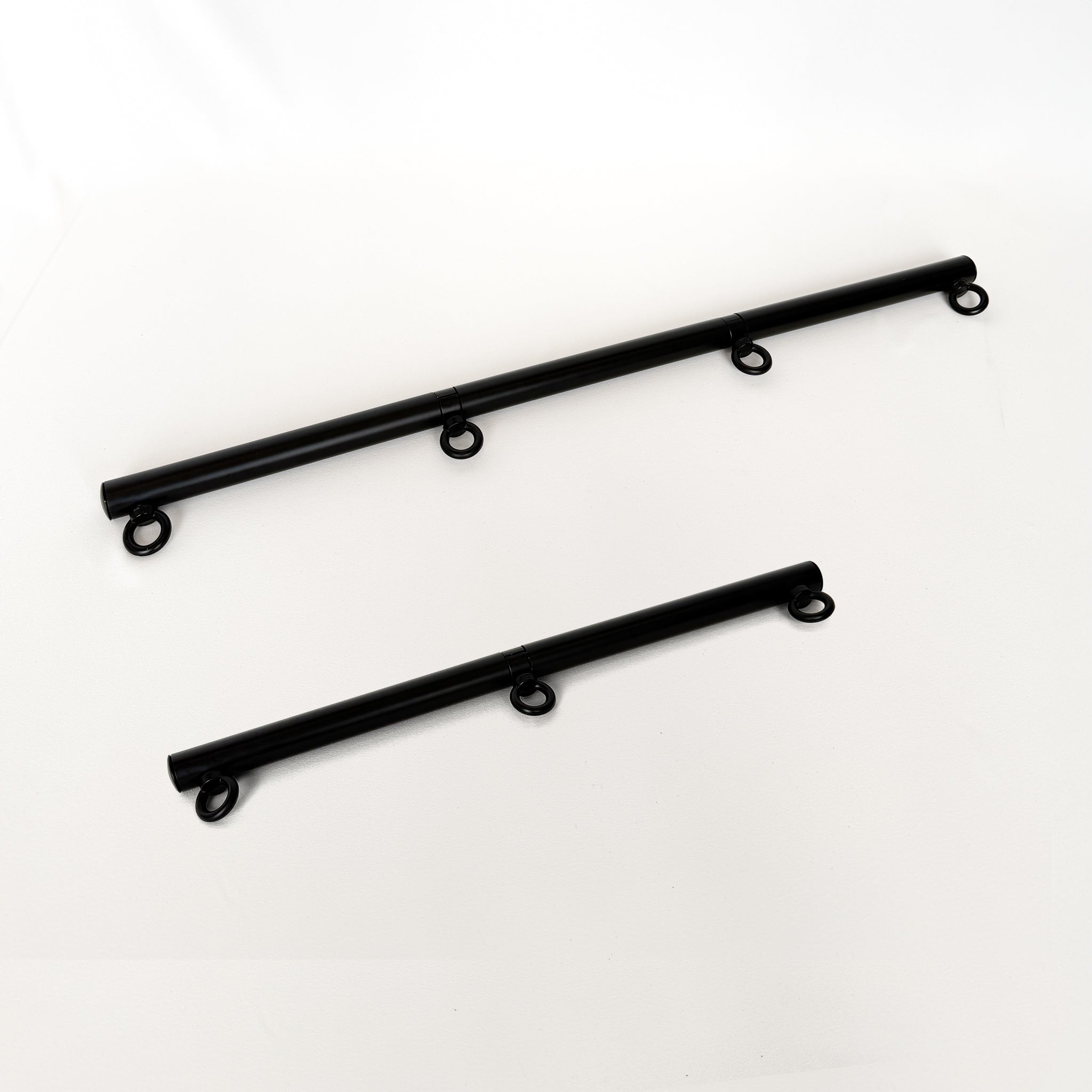 two black spreader bar rods with ring connectors