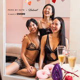 Three women in lingerie sitting together with drinks and a pink background, featuring Perk by Kate and Hedonist branding. In support of AWARE Sinagapore